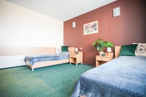 Cette chambre d'hôtel comprend 2 lits et de la moquette verte. dans l'établissement Hotel Wilanów, à Varsovie