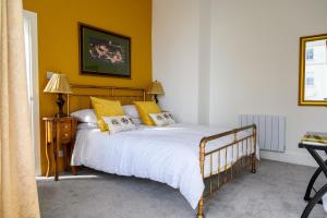 a bedroom with a large bed with yellow walls at The Sandbeck, Glaisdale in Whitby