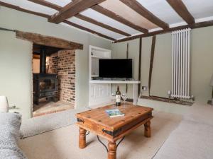 sala de estar con mesa de madera y TV en The Nook en Cavendish