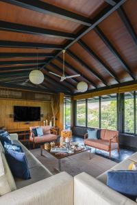 a living room with two couches and a table at LohonoStays Villa Orchard House in Revas