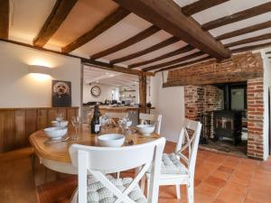 a dining room with a wooden table and white chairs at The Nook in Cavendish