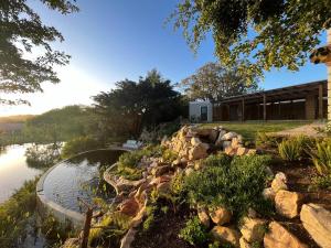 a garden with a pond and a building at Kwendalo in Plettenberg Bay