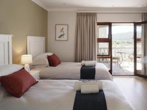 Una habitación de hotel con dos camas y balcón. en Kwendalo, en Plettenberg Bay