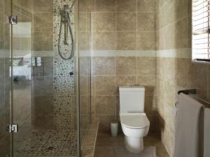 un baño con inodoro y ducha en Kwendalo, en Plettenberg Bay 10 fotos más