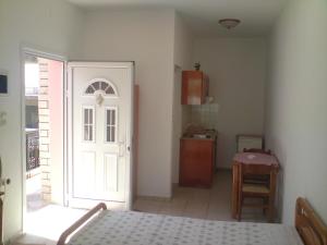 a bedroom with a door and a kitchen with a table at TEO Studios in Kastrosikia