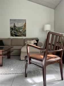 een houten stoel in een woonkamer met een bank bij Tyylikäs koko perheen huoneisto in Vuokatti