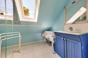 a blue bathroom with a sink and a mirror at Séjour tout confort à St Gildas de Rhuys in Saint-Gildas-de-Rhuys +17 photos