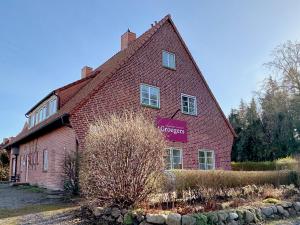 a red brick building with a sign on it at Groegers Ferienzimmer in Hohwacht