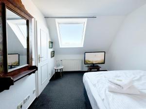 a bedroom with a bed and a window and a television at Groegers Ferienzimmer in Hohwacht