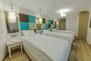 Una habitación de hotel con dos camas y un espejo. en The Constantine Hotel, en Estambul