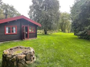 uma pequena cabana num jardim relvado com uma pedra em Charming Cottage em Roskilde