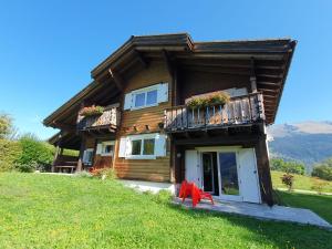 a log house with a red table in front of it at Chalet Dalpe by Quokka 360 - chalet among pastures and forests in Dalpe