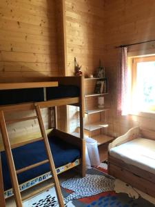 a bedroom with bunk beds in a log cabin at Chalet Dalpe by Quokka 360 - chalet among pastures and forests in Dalpe