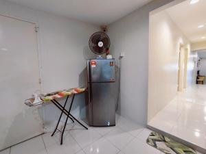 a kitchen with a refrigerator and a table in it at TREX_Batu Pahat Homestay in Batu Pahat