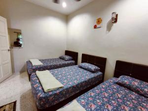 een kamer met drie bedden in een kamer bij TREX_Batu Pahat Homestay in Batu Pahat