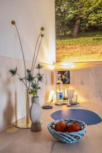 einen Tisch mit einer Schale Obst und eine Vase mit Blumen in der Unterkunft Hotel Restaurant Elbebrücke in Oranienbaum-Wörlitz