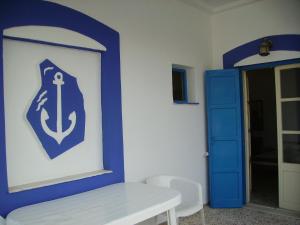 a blue and white wall with a door and a table at Studios Happiness in Panteli