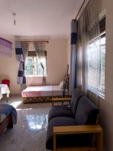 a living room with a couch and a bed at Contra Hotel in Jinja