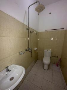 uma casa de banho com um chuveiro, um WC e um lavatório. em Contra Hotel em Jinja