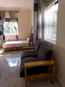 a living room with a couch and a bed at Contra Hotel in Jinja
