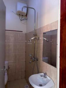 a bathroom with a sink and a shower at Contra Hotel in Jinja