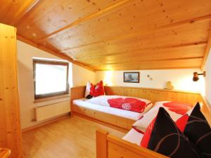 1 Schlafzimmer mit 2 Betten in einem Zimmer mit Holzdecken in der Unterkunft Apartment in Bramberg am Wildkogel with balcony in Bramberg am Wildkogel