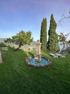 una fuente en la hierba en un parque con dos mesas de picnic en Villa Barluzzi, en Ravello