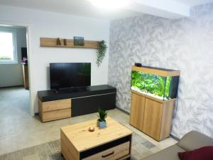 a living room with a fish tank and a tv at Ferienwohnung Familie Mergner in Bad Langensalza