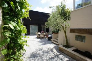 a courtyard of a house with a table and a tree at B&B Wellness Yoake in Ypres