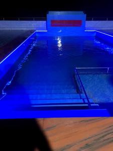una gran piscina con luces azules. en Hotel Orion International en Jessore
