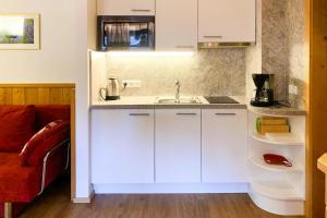 - une cuisine avec des placards blancs et un évier dans l'établissement Apartment in K nigsleiten with a shared sauna, à Königsleiten