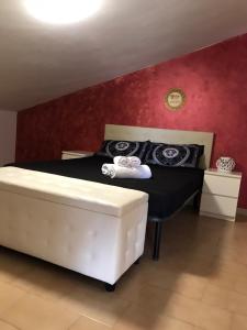 1 dormitorio con cama blanca y pared roja en Atena B&B APARTMENTS Imperial, en San Silvestro