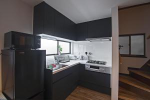 a kitchen with black cabinets and a black refrigerator at 旅time 住吉大社 Sumiyoshi shrine in Osaka