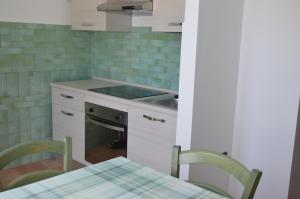 uma cozinha com um fogão e uma mesa com cadeiras em Country House Il Papavero Rosso em Francavilla al Mare