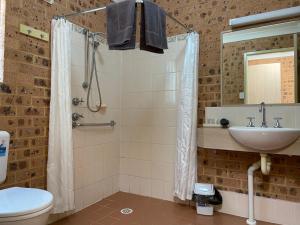 a bathroom with a shower and a toilet and a sink at Aberdeen Motel in Aberdeen