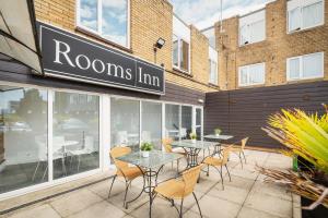 un restaurante con mesas y sillas frente a un edificio en Rooms Inn en Newcastle