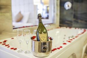 una botella de champán en un cubo junto a dos copas de vino en The Constantine Hotel, en Estambul