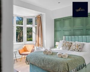 a green and white bedroom with a bed and a chair at Luxury 6 bed 6 En-suite - Free Parking Reading in Reading