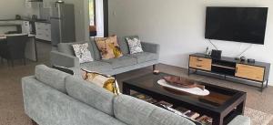 a living room with a couch and a tv at Temata Estate Rarotonga in Rarotonga
