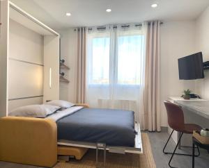 a bedroom with a bed and a table and a desk at Le Refuge du Bord de Mer 2 pers- Studio avec parking à 500m de la mer in Houlgate +35 photos