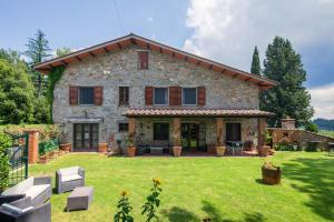 een uitzicht op een groot stenen huis bij Casale Montelucci by VacaVilla in Gaiole in Chianti
