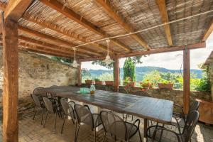 een patio met een houten tafel en stoelen bij Casale Montelucci by VacaVilla in Gaiole in Chianti