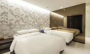 een slaapkamer met 3 bedden en een muur met bloemen bij Incheon Guwol Hotel Bay 204 in Incheon