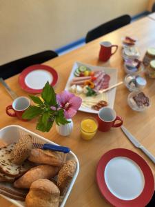 una mesa de madera con platos de comida. en Nordsee Jugendheim Delphin, en Husum