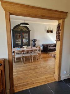 a living room with a table and chairs and a couch at Maison Les Roses in Marmagne
