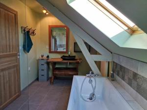 a bathroom with a bath tub and a sink at Maison Les Roses in Marmagne