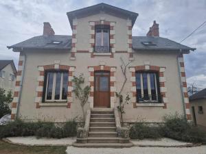 a house with stairs in front of it at Maison Les Roses in Marmagne