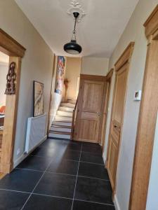 a hallway with a door and a tiled floor at Maison Les Roses in Marmagne