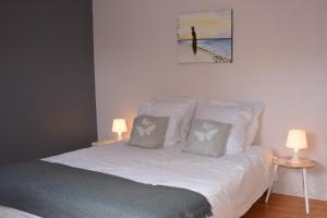 - une chambre avec un lit, 2 tables et 2 lampes dans l'établissement La Villa Bernard, à Varennes-sur-Loire