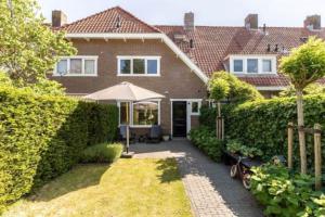 a house with an umbrella in the yard at Beautiful house close to Amsterdam Beach and Haarlem in Aerdenhout